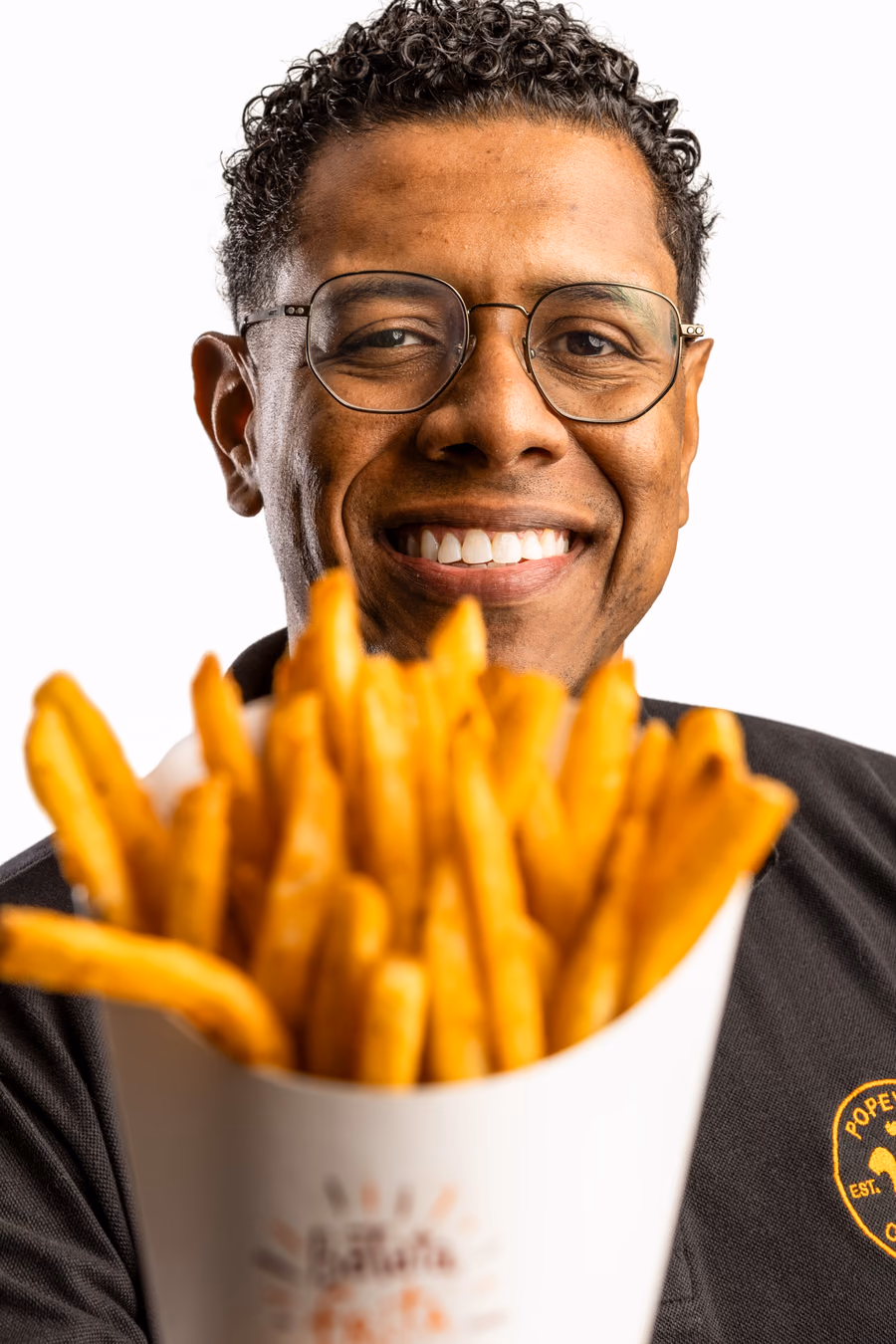 Colaborador do Popeyes com batata frita e copo; em seguida, a foto troca e aparece uma barista do Starbucks com um copo